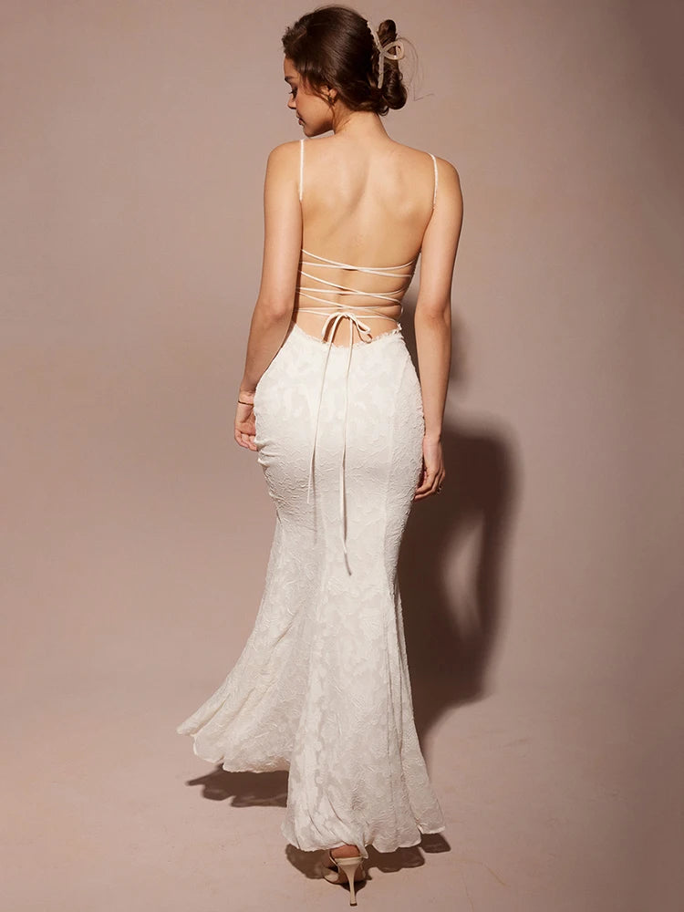 Close-up of the lace-up detail on the back of sexy white maxi dress.
